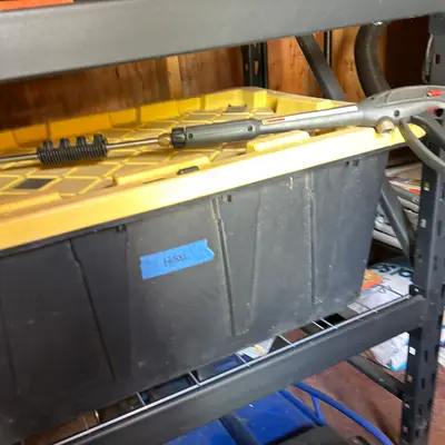 Hose storage bin with pump sprayer